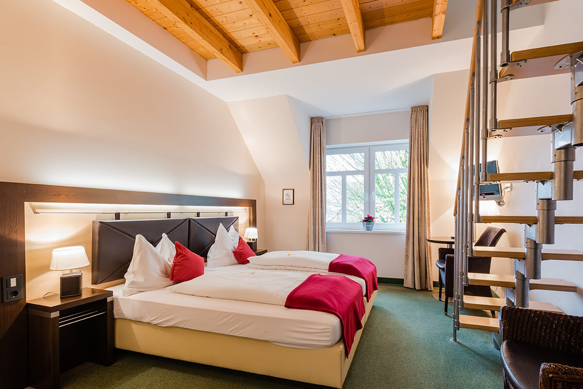 Gemütliches Zimmer mit großem Bett und frischen Blumen im Hotel am Fischerhafen
